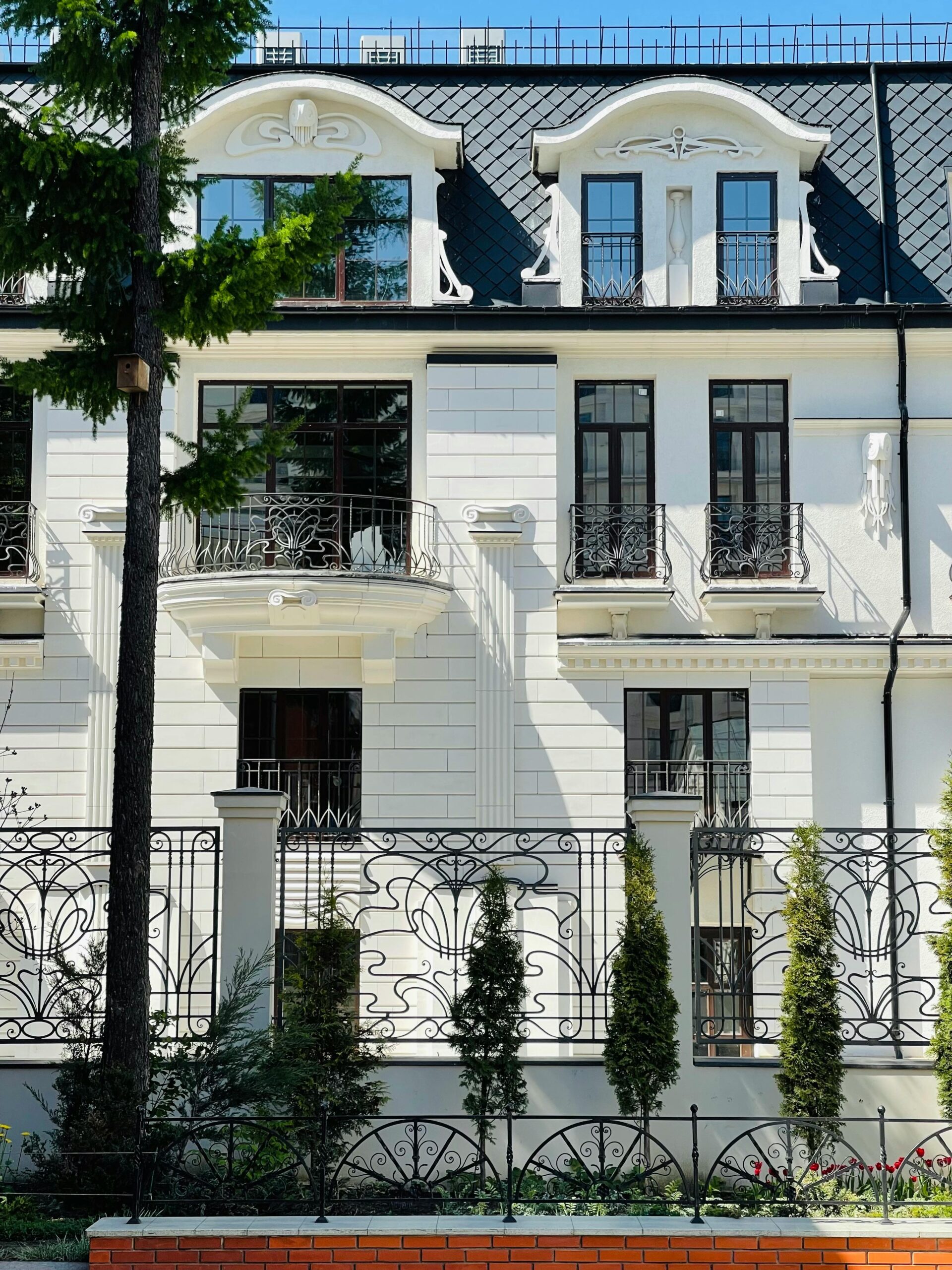 A luxury neo-classical residential building facade in Moscow, featuring ornate balconies and intricate ironwork.